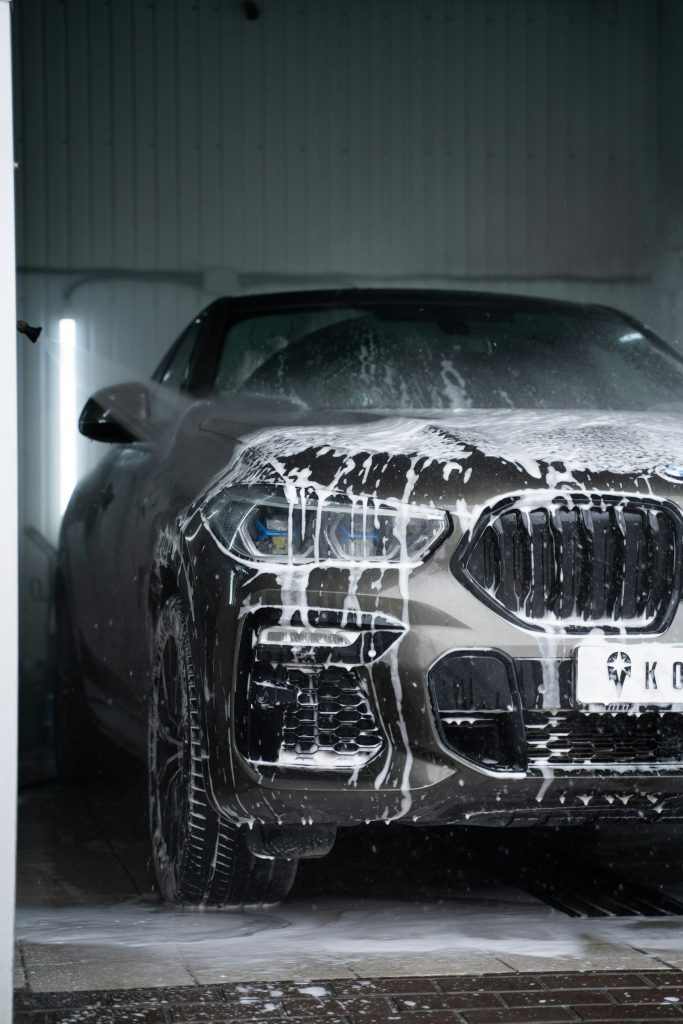 Đầu xe SUV phủ lớp bọt trắng đang chảy xuống